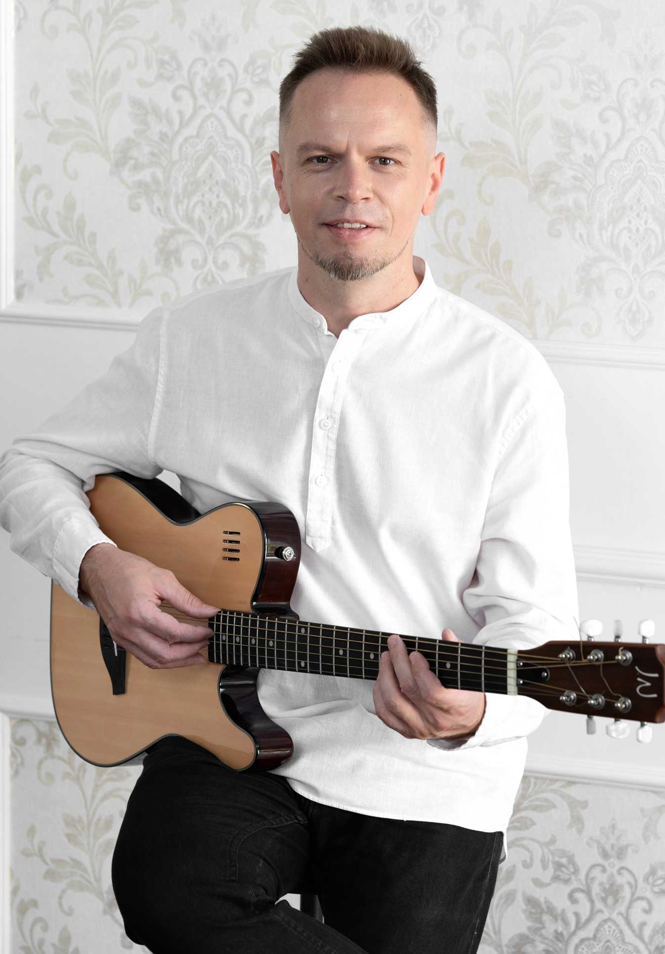 Portret Oleksandra Hrechaniuka z gitarą
